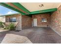 Covered parking space with brick columns and a decorative 'WELCOME' sign on a brick accent wall at 10440 W Devonshire Ave, Phoenix, AZ 85037