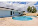 Backyard pool with a blue house and covered patio, perfect for outdoor entertaining at 12607 N 25Th Ave, Phoenix, AZ 85029