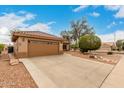 Charming single-story home with a well-maintained lawn and large driveway leading to a two-car garage at 15026 W Cactus Ridge Way, Surprise, AZ 85374