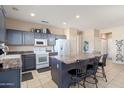 Spacious kitchen with granite countertops, stainless steel appliances, and breakfast bar seating at 15560 W Clear Canyon Dr, Surprise, AZ 85374
