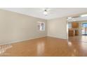 Bright living room with wood floors, a ceiling fan, and large windows that fill the space with natural light at 1563 S 227Th Ave, Buckeye, AZ 85326