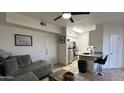 Cozy living space featuring a comfortable gray sofa, modern ceiling fan, and adjacent open kitchen at 1701 E Colter St # 138, Phoenix, AZ 85016