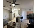 Comfortable living area open to the kitchen, featuring a ceiling fan and neutral decor at 1701 E Colter St # 138, Phoenix, AZ 85016