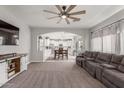 Spacious living room open to kitchen featuring carpet floors and a decorative ceiling fan at 24805 W Vista Norte St, Buckeye, AZ 85326