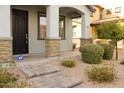 Inviting front porch with stone accents on columns, desert landscaping and a secured front door at 250 N Sandal --, Mesa, AZ 85205