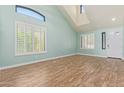 Bright living room showcasing tile floors, a vaulted ceiling, large windows with shutters, and fresh light blue walls at 41581 W Somerset Dr, Maricopa, AZ 85138