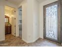 Elegant foyer with a decorative wrought iron front door and access to a half bath at 4576 E Waterman St, Gilbert, AZ 85297