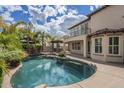 Backyard with a sparkling pool, mature palm trees, patio area, and second story balcony at 4576 E Waterman St, Gilbert, AZ 85297