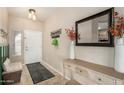 Inviting entryway with neutral walls, tile floors, decorative mirror, and coat rack at 4610 S Hassett Cir, Mesa, AZ 85212