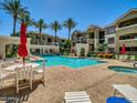 Resort-style pool with lounge chairs, tables, and lush palm trees offering a perfect outdoor oasis at 5303 N 7Th St # 134, Phoenix, AZ 85014