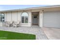 Inviting front entrance with a stone pathway, chairs, and gray garage door at 6225 W Mary Jane Ln, Glendale, AZ 85306