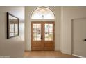 Inviting entryway with beautiful wood flooring and stylish glass paneled double doors at 6232 E Monte Cristo Ave, Scottsdale, AZ 85254