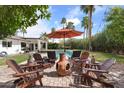 Relaxing backyard featuring a swimming pool, patio with comfortable seating, and mature palm trees at 7435 E Corrine Rd, Scottsdale, AZ 85260