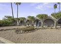 Front yard with desert landscaping and fountain leading to a charming home featuring arched entryways and a blue door at 8240 E Pueblo Ave, Mesa, AZ 85208
