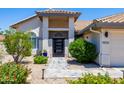 Inviting front entrance with a stylish doorway, tile walkway, and colorful landscaping at 9032 E Larkspur Dr, Scottsdale, AZ 85260