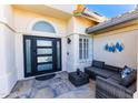 Cozy front porch featuring a modern black framed glass door and comfortable outdoor seating area at 9032 E Larkspur Dr, Scottsdale, AZ 85260