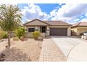 Charming single-story home with a well-manicured front yard and a brick paver walkway at 11831 W Daley Ct, Sun City, AZ 85373