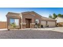 Single-story home featuring desert landscaping, a covered entryway, and a spacious three-car garage at 1294 W Chimes Tower Dr, Casa Grande, AZ 85122