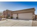 Spacious three-car garage adjacent to a single-story home with desert landscaping at 1294 W Chimes Tower Dr, Casa Grande, AZ 85122