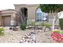 Close up of the desert landscaping featuring rocks, flowering bushes, and a small tree at 13487 E Gold Dust Ave, Scottsdale, AZ 85259