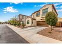 Charming two-story home features a brown two-car garage, stucco facade, and a delightful wrought-iron balcony at 1548 W Windhaven Ave, Gilbert, AZ 85233