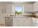 Kitchen with stainless steel dishwasher, white cabinets, tile floor and a window with a view at 1978 E Connemara Dr, San Tan Valley, AZ 85140