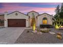 Inviting single-story home featuring a desert-style front yard, stucco exterior, and a two-car garage at 21854 N 263Rd Dr, Buckeye, AZ 85396