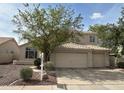 Inviting two-story home featuring a tile roof and a spacious three-car garage with landscaped front yard at 243 W Candlewood Ln, Gilbert, AZ 85233