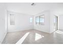 Bright living room with multiple windows that bring in natural light and neutral-toned tile floors at 25286 N 156Th Ln, Surprise, AZ 85387