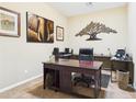 Home office with rich wood desk and decorative tree sculpture against a neutral paint color at 264 S San Luis Rey Trl, Casa Grande, AZ 85194