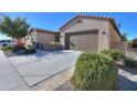 Spacious driveway leading to a two-car garage with desert landscaping and a charming home exterior at 391 N San Ricardo Trl, Casa Grande, AZ 85194