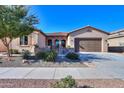 Inviting front exterior with a well-kept lawn, mature tree, and stone-accented entryway at 391 N San Ricardo Trl, Casa Grande, AZ 85194