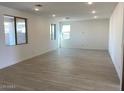 Spacious living room featuring neutral-toned tile floors and natural light from three windows at 7208 E Purple Prairie Dr, San Tan Valley, AZ 85143