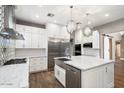 Bright kitchen features stainless appliances, quartz countertops, stylish pendants and custom backsplash at 7309 E Rovey Ave, Scottsdale, AZ 85250