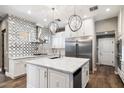 Beautiful kitchen with stainless steel appliances, chic light fixtures, and designer tile backsplash at 7309 E Rovey Ave, Scottsdale, AZ 85250