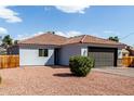 Single story home with low maintenance landscaping, tile roof, and dark garage door at 7715 N 23Rd Ave, Phoenix, AZ 85021