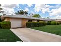 Charming single-story home with a brick facade, a one-car garage, and a spacious driveway at 9625 W Oak Ridge Dr, Sun City, AZ 85351