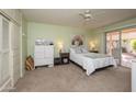 Comfortable bedroom with a queen bed, sliding glass doors to a patio, and ceiling fan at 10443 W Loma Blanca Dr, Sun City, AZ 85351