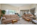 Bright living room with neutral walls, plush couches, and large windows for natural light at 10443 W Loma Blanca Dr, Sun City, AZ 85351
