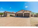Large driveway leads to a three-car garage with mature desert landscaping at 10649 E Saddle Blanket Trl, Gold Canyon, AZ 85118