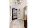 Elegant foyer featuring a wrought iron front door and arched doorways at 10649 E Saddle Blanket Trl, Gold Canyon, AZ 85118