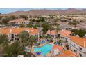 An aerial view showcases a community pool, buildings with red roofs, and lush landscaping at 11375 E Sahuaro Dr # 2033, Scottsdale, AZ 85259