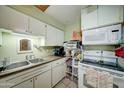 Functional kitchen with white cabinetry, double sink, and essential appliances for easy meal preparation at 11509 E Marguerite Ave, Mesa, AZ 85208