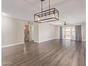Spacious living room featuring hardwood floors, modern lighting, and slider doors to the patio at 11671 S Jokake St, Phoenix, AZ 85044