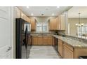 Well-lit kitchen featuring granite counters, light wood cabinets, and black appliances at 14000 N 94Th St # 2144, Scottsdale, AZ 85260