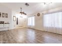 Bright living room features wood floors and natural light from large windows at 14931 W Redfield Rd, Surprise, AZ 85379