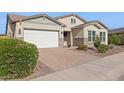 Beautiful home showcasing a brick driveway, a manicured lawn, and stone accents at 18324 W Highland Ave, Goodyear, AZ 85395
