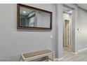 A home's hallway features a bench and a large mirror enhancing the sense of space at 18324 W Highland Ave, Goodyear, AZ 85395