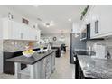Open-concept kitchen with a center island, pendant lighting, and a view into the adjacent dining area at 18327 N Summerbreeze Way, Surprise, AZ 85374