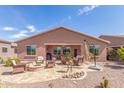 Expansive backyard featuring a cozy fire pit, lounge area, and low-maintenance desert landscaping at 19932 N Ibis Way, Maricopa, AZ 85138